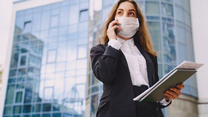Wanita bermasker sedang menelepon
