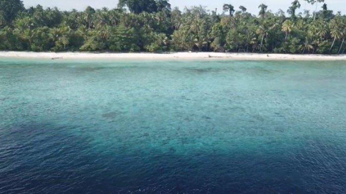 Tampak air laut yang jernih dan pasir putih yang menawan di Pantai Anggopi.