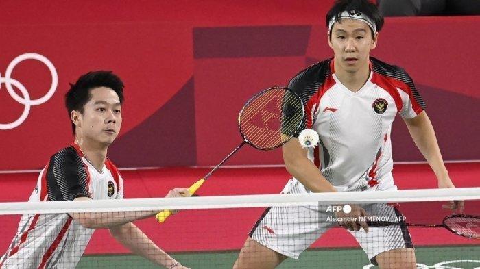 Pebulutangkis Indonesia Marcus Fernaldi Gideon (kiri) melakukan pukulan di sebelah Kevin Sanjaya Sukamuljo dari Indonesia dalam pertandingan penyisihan grup bulu tangkis ganda putra melawan Chirag Shetty dari India dan Satwiksairaj Rankireddy dari India selama Olimpiade Tokyo 2020 di Musashino Forest Sports Plaza di Tokyo pada 26 Juli, 2021.