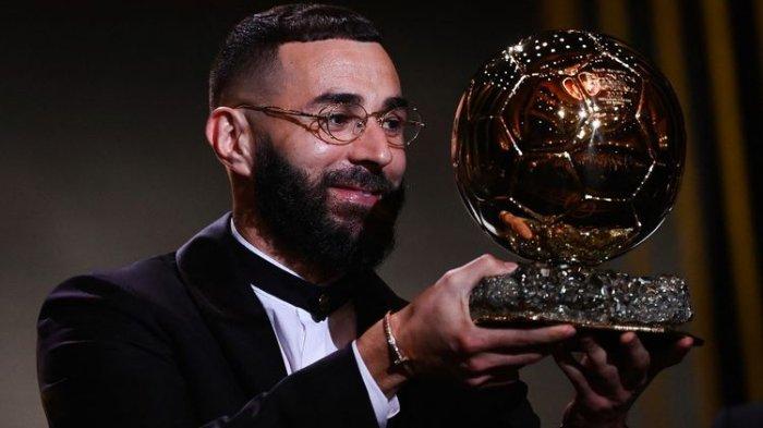 Karim Benzema, berpose bersama trofi Ballon d'Or 2022, lambang supremasi pesepak bola terbaik.