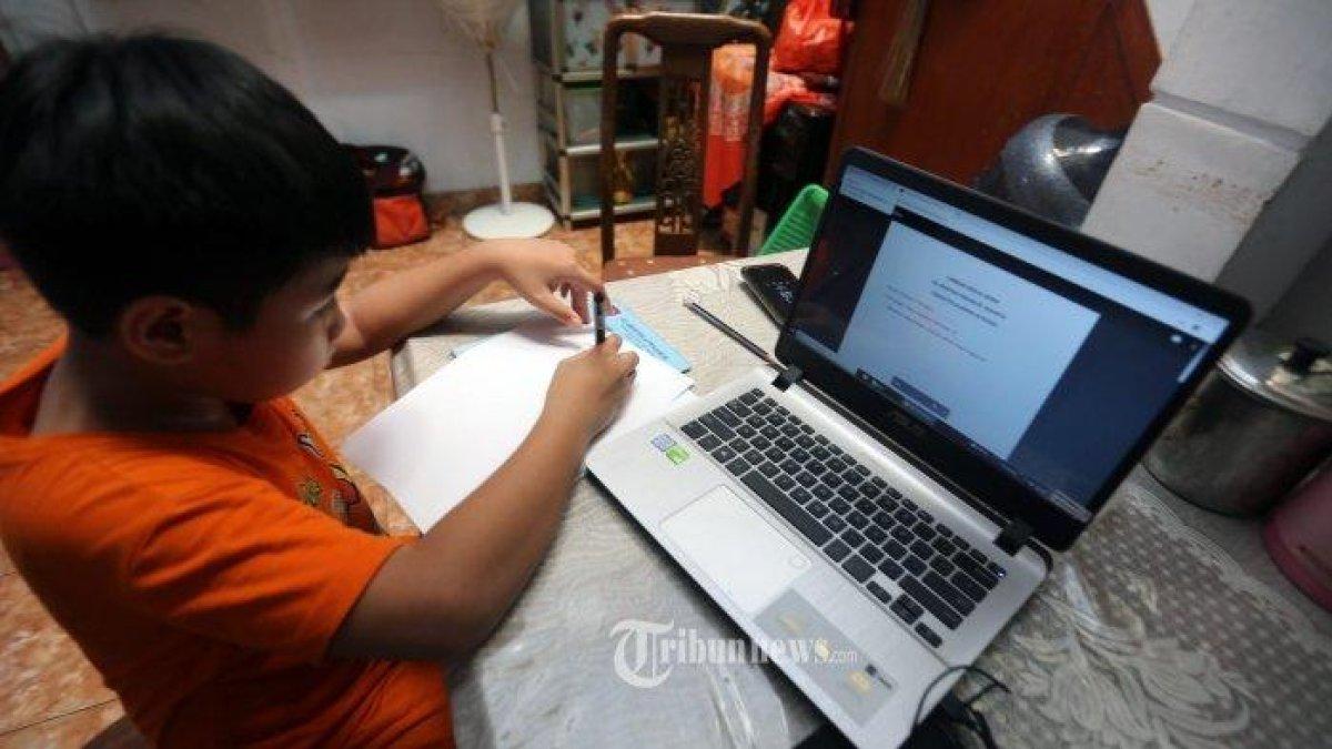 Christabel, siswa SDK Penabur, Duren Sawit, mengerjakan tugas sekolah di rumahnya di kawasan Jatinegara, Jakarta Timur, Jumat (27/3/2020). Ia menggunakan situs Google Classroom untuk menerima pelajaran dari gurunya yang juga mengajar dari rumah saat terjadinya wabah Covid-19. (Warta Kota/Alex Suban