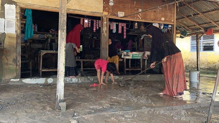 Warga membersihkan lumpur pasca terendam banjir di Kampuang Galapuang, Padang Pariaman, Sabtu (5/10/2024). 