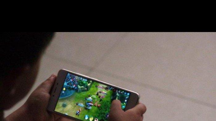 MAIN GAME ONLINE - Potret seorang anak yang sedang asik main game online. Game online merupakan salah satu aplikasi game (hiburan) di gadget yang sangat diminati oleh banyak orang  yang tidak lagi mengenal usia.