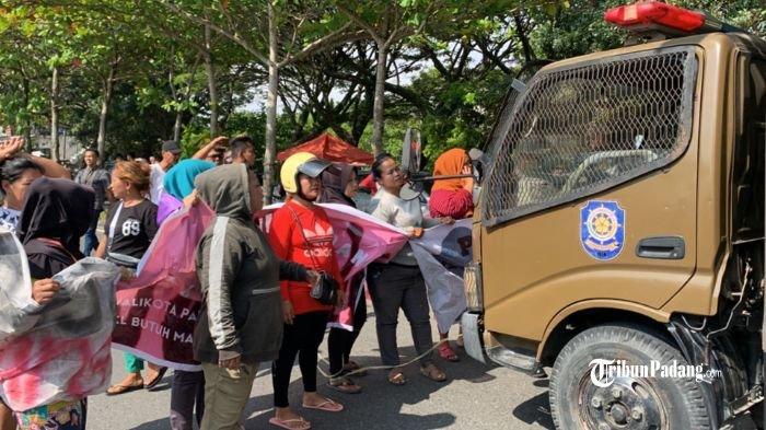 Pedagang kaki lima (PKL) Pantai Danau Cimpago menghadang kendaraan truk Satpol PP Kota Padang, Sumbar, Jumat (22/9/2023).