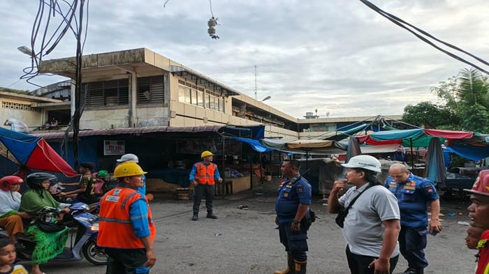 GARDU LISTRIK RUBUH: Sejumlah petugas saat mengecek kondisi tiang gardu listrik yang rubuh di Pasar Raya Padang, Rabu (30/7/2025). Gardu tersebut karena tiang penyangga yang sudah keropos.