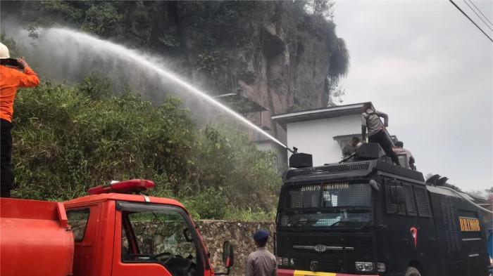 KARHUTLA DI SUMBAR- Petugas saat melakukan pemadaman api yang membakar lahan di Jorong Lubuak Limpato, Nagari Tarantang, Kecamatan Harau, Kabupaten Lima Puluh Kota, Sumatera Barat, Rabu (23/7/2025). Petugas kepolisian yang ikut membantu mengirimkan kendaraan water cannon.