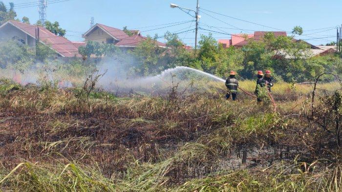 KEBAKARAN LAHAN- Petugas dari Damkar Kota Padang pada saat berusaha memadamkan api yang membakar lahan kosong di Jalan Selaguri, Rt 02/Rw 03, Kelurahan Parupuk Tabing, Kecamatan Koto Tangah, Kota Padang, Sumatera Barat (Sumbar), Jumat (13/6/2025). Kabid Ops Sarpras Damkar Kota Padang, Rinaldi, mengatakan dikerahkan sebanyak dua unit mobil damkar untuk membantu pemadaman.