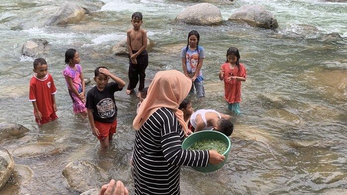 MANDI BALIMAU - Masyarakat bersama anak-anaknya melaksanakan kegiatan 'balimau' di aliran sungai, Kelurahan Padang Besi, Kecamatan Lubuk Kilangan, Kota Padang, Provinsi Sumatera Barat, Rabu (26/2/2025). Kegiatan ini bermakna mensucikan diri dalam menyambut bulan suci Ramadhan.