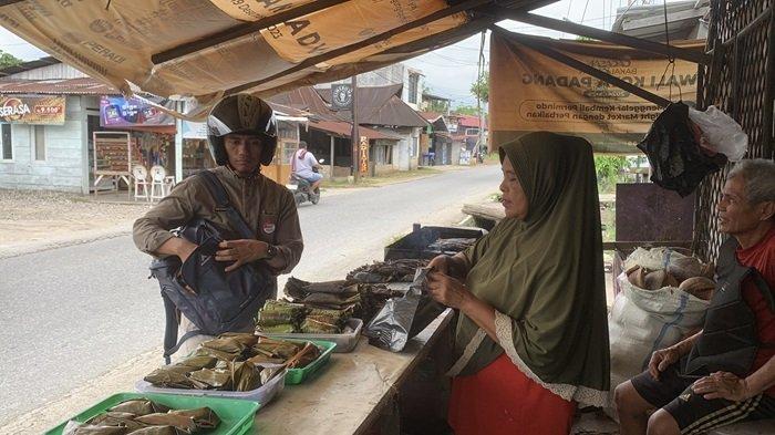 KULINER RAMADAN - Nurjani (56) melayani pembeli di warungnya di Jalan Kuranji, Kelurahan Korong Gadang, Kecamatan Kuranji, Kota Padang, Provinsi Sumatera Barat, Selasa (4/3/2025). Palai bada dan lompong sagu menjadi makanan yang cukup banyak dicari oleh masyarakat pada saat bulan suci Ramadan.
