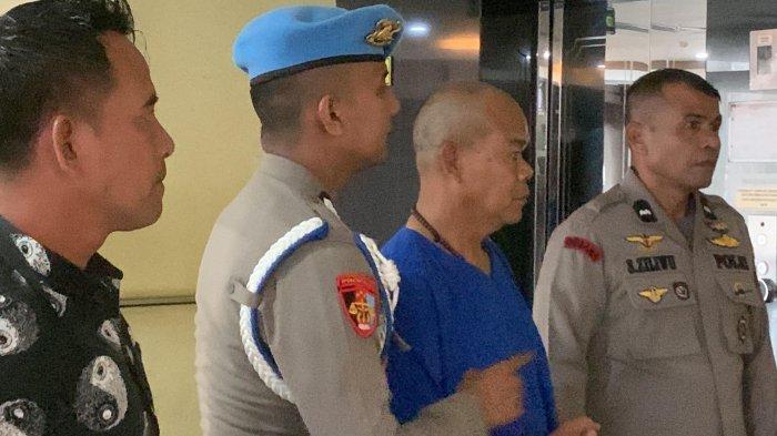 Penampakan AKP Dadang Iskandar, Kabag Ops Polres Solok Selatan yang menembak mati Kasat Reskrim Polres Solok Selatan saat digiring polisi jelang update kasus polisi tembak polisi di Mapolda Sumbar, Sabtu (23/11/2024) siang. Tersangka terlihat memakai baju tahanan berwarna biru dengan rambut plontos dan dijaga petugas. Saat digiring AKP Dadang Iskandar terlihat pasrah dengan memakai kalung kayu ulin di leher