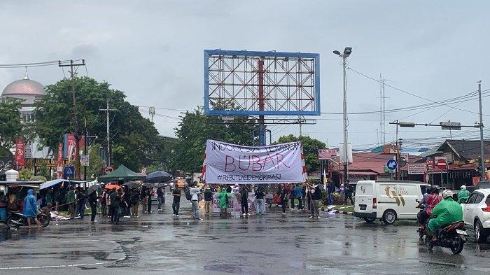 Peserta aksi kawal putusan MK di depan DPRD Provinsi Sumatera Barat saat turun hujan, Kamis (22/8/2034).