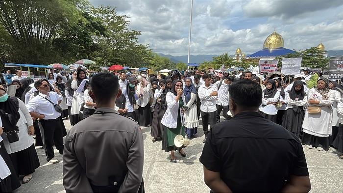 DEMO PPPK - Ribuan tenaga honorer menggelar aksi damai untuk kepastian nasib mereka di halam kantor bupati, Parit Malintang, Padang Pariaman, Sumatera Barat, Kamis (31/7/2025). Ribuan tenaga honorer ini terdiri dari guru, tenaga administrasi sekolah, penjaga sekolah, nakes, sopir ambulan dan lainnya, mereka berkeja di sekolah dan layanan kesehatan.