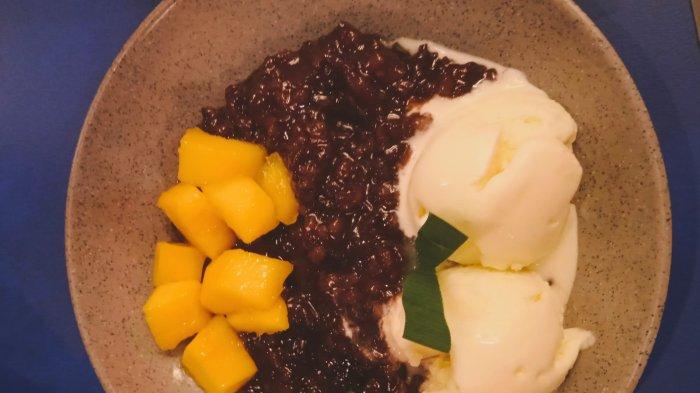 BUBUR KETAN HITAM: Semangkuk bubur ketan hitam disajikan dengan tambahan es krim dan potongan buah mangga yang lembut serta manis  pada minggu (29/12/2024) di Cafe Wabe Padang. Kuliner ini, termasuk yang digemari sebagai pilihan saat menikmati sajian menu berbuka puasa selama ini.