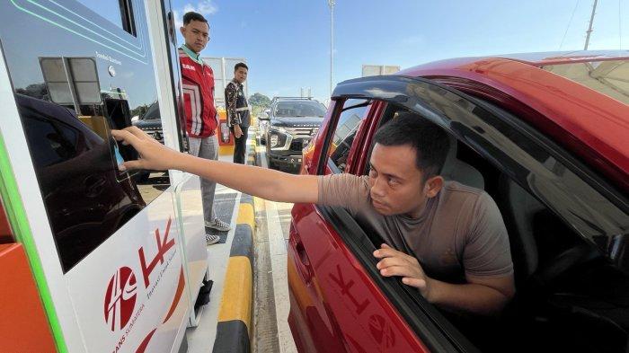 Seorang pengendara menempelkan kartu uang elektronik untuk masuk ke Jalan Tol Padang-Sicincin di Sumatera Barat (Sumbar) pada Jumat (27/12/2024) sore.