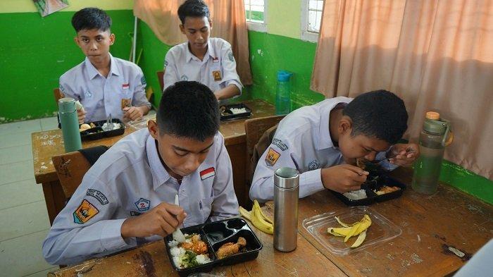 Siswa di Kota Pariaman menggunakan perlengkapan makan sendiri untuk menyantap makanan bergizi gratis, Senin (6/1/2025).