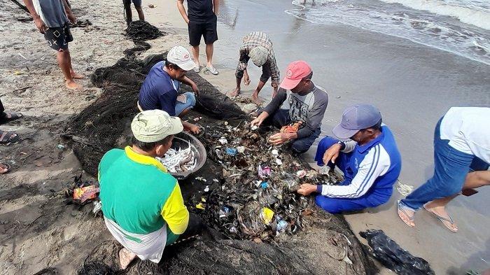 TRADISI MAELO PUKEK: Kelompok nelayan elo pukek pada saat memilah ikan dari sampah yang ikut masuk ke dalam jaringnya di Jalan Samudera, Purus, Kecamatan Padang Barat, Kota Padang, Provinsi Sumatera Barat, Sabtu (8/3/2025). Hasil tangkapan sangat sedikit, dan lebih banyak sampah.