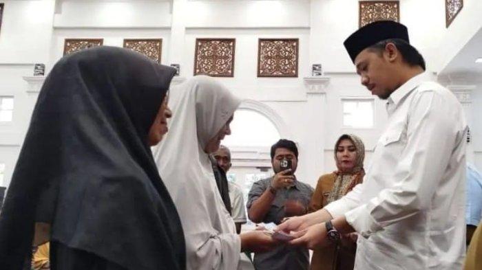 Wako Erman Safar saat menyerahkan bantuan zakat bagi masyarakat kurang mampu.