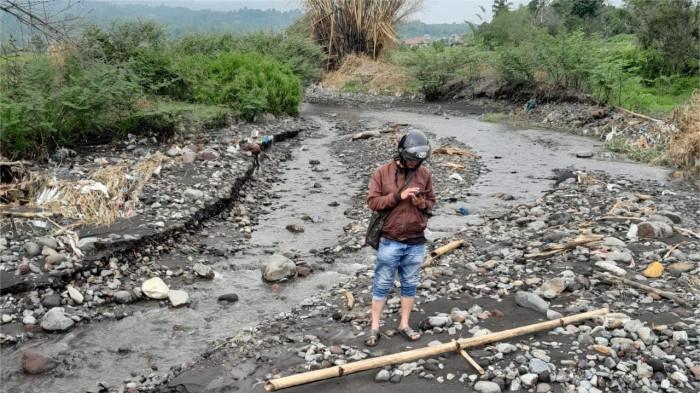 PENDANGKALAN ALIRAN SUNGAI- Salah seorang warga saat mengecek kondisi aliran sungai di Nagari Batu Taba, Kecamatan Ampek Angkek, Kabupaten Agam, Provinsi Sumatera Barat, Sabtu (26/7/2025). Kondisi aliran sungai tersebut mengalami pendangkalan dan membuat warga sekitar khawatir potensi banjir bandang kembali terjadi.