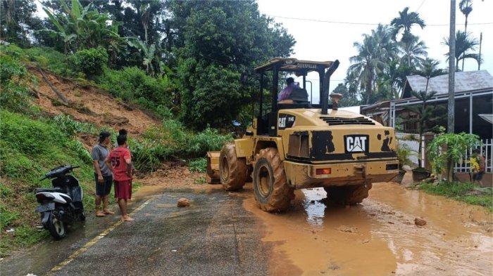 BENCANA LONGSOR- Petugas menurunkan alat berat untuk membersihkan material longsor yang menutup badan jalan di kawasan Barung-Barung Balantai Tengah, Kecamatan Koto XI Tarusan, Pesisir Selatan, Sumbar, Senin (14/7/2025). Jalan sempat lumpuh akibat tertutup material, namun kini sudah bisa dilalui secara bergantian.