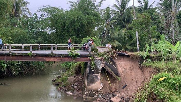 Jembatan penghubung antara Nagari Cimpago Barat dengan Nagari Pilubang, V Koto Kampung Dalam, Kabupaten Padang Pariaman, Sumatera Barat mengalami kerusakan akibat luapan air Sungai Paku, Rabu (20/11/2024).