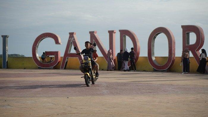 Seorang anak kecil memboncengi temannya menggunakan sepeda listrik dianjungan pantai Gandoriah kota Pariaman, Kamis (11/5/2023).