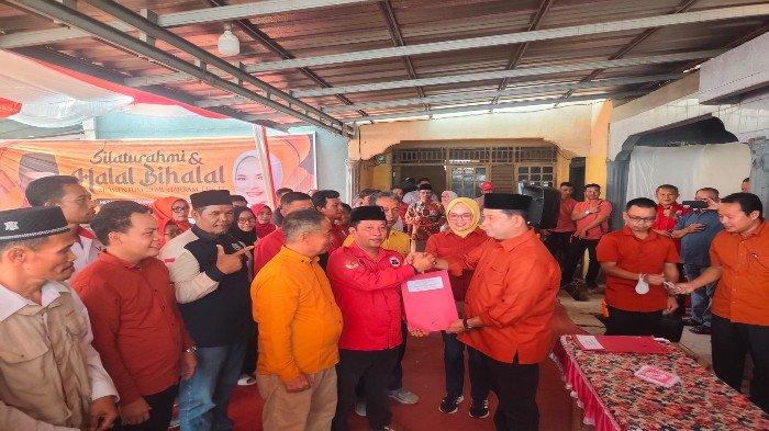 Calon Bupati Banyuasin H Askolani Jasi dan Calon Wakil Bupati Banyuasin Netta Indian saat mengukuhkan dan menyerahkan surat keputusan relawan ASTA di Kecamatan Banyuasin III, Senin (29/7/2024).