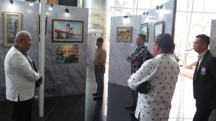 Dirut Bank Sumsel Babel (BSB) Achmad Syamsudin melihat lukisan yang dipamerkan oleh sejumlah pelukis di lobi BSB pusat Jakabaring Palembang, Jumat (27/10/2023).