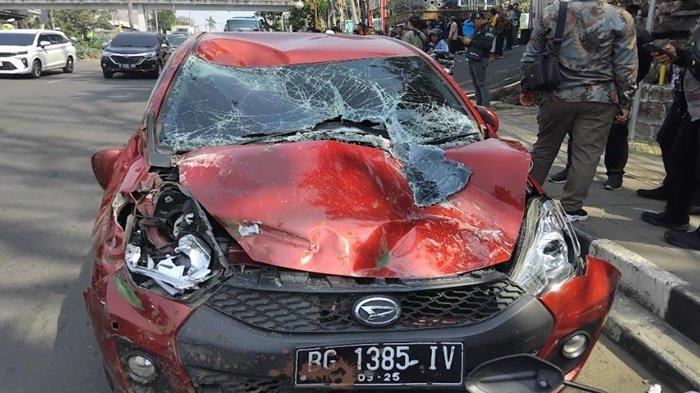 Mobil Sirion jadi korban laka di depan SMAN 3 Palembang.