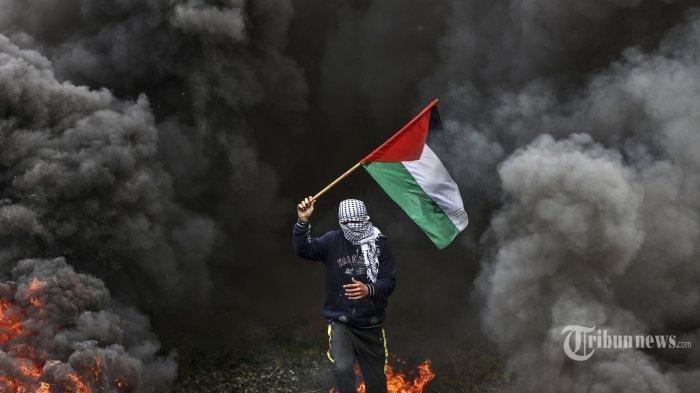 Pemuda Palestina membakar ban selama protes di dekat perbatasan Israel-Gaza di sebelah timur kamp pengungsi Jabalia, pada 23 Februari 2023.