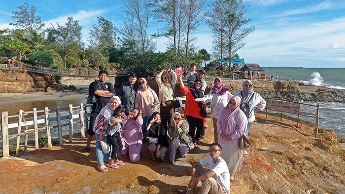 Rombongan wisata dari Palembang berfoto bersama di Pantai Sungai Suci, Bengkulu, Minggu (14/1/2024).