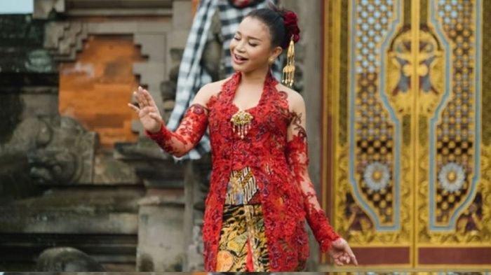 Rossa tampil di televisi Cina mengenakan baju kebaya berwarna merah.