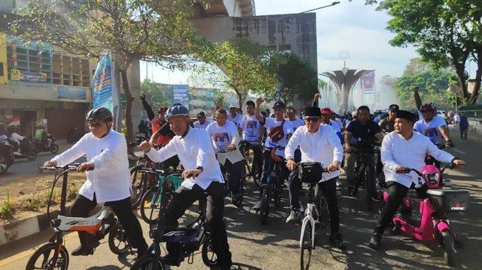 Pasangan calon Walikota dan Wakil Walikota Palembang, Yudha Pratomo Mahyuddin dan Baharuddin arak-arakan bersepeda dari Bundaran Air Mancur menuju Kantor KPU Palembang, Selasa (27/8/2024).
