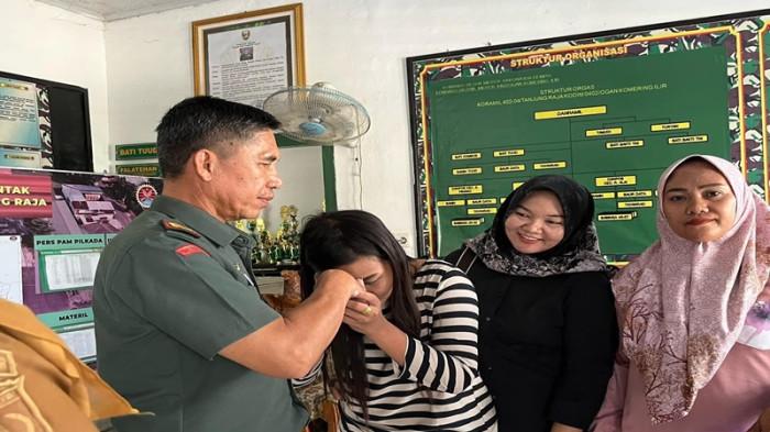 CIUM TANGAN - Konten kreator Lilie Putri Rojlah mencium tangan Danramil 402-04/Tanjung Raja, Kapten Inf Samsul Rizal, Senin (21/7/2025). Dalam kunjungan tersebut, Lilie menyampaikan permohonan maaf atas unggahan yang menyinggung gaji TNI.