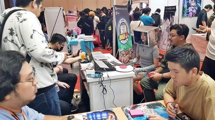 Beberapa pengunjung memainkan game Digimon Rumble arena di booth Komunitas Digi-In di event Indonesia Comic Con 2024 yang digelar pada 9-10 November 2024.