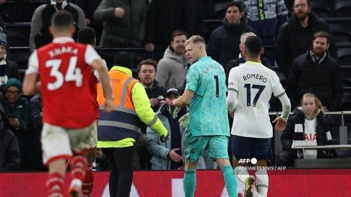 Seorang steward berusaha menenangkan penjaga gawang Inggris Arsenal yang tidak senang, Aaron Ramsdale, setelah pertandingan sepak bola Liga Utama Inggris antara Tottenham Hotspur dan Arsenal di Stadion Tottenham Hotspur di London, pada 15 Januari 2023. Arsenal memenangkan pertandingan 2-0.