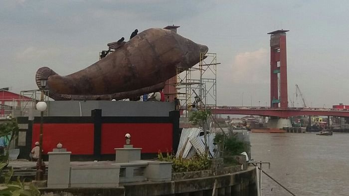 Tugu Belido yang sudah dinanti-nantikan warga Kota Palembang, kini sudah berdiri di pinggir Sungai Musi, Benteng Kuto Besak (BKB), Rabu (2/7/2017). Sejumlah pekerja terlihat merapikan badan belido yang terbuat dari tembaga tersebut.