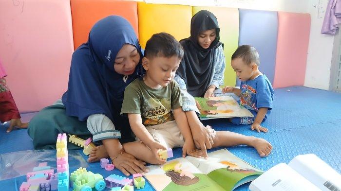 Orangtua mendongengkan buku cerita 'Menyambut saat Noni Datang' kepada anaknya di Rumah Anak SIGAP Kluwut, Kabupaten Brebes, Selasa (19/11/2024).