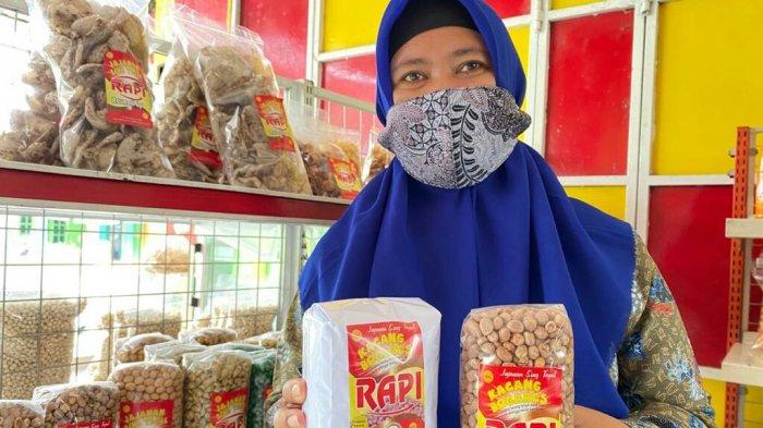 Pemilik Toko Oleh-oleh Kacang Bogares RAPI, Supriyati atau Upi (46), saat menunjukan kemasan kacang bogares yang dijual di toko miliknya yang beralamat di jalan raya Bogares Kidul, RT 2 RW 1, Kecamatan Pangkah, Kabupaten Tegal, Minggu (25/7/2021).
