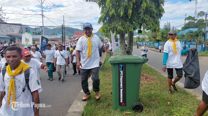 Peserta grebeg sampah sedang berjalan sembari mengutip sampah di sepanjang jalan Distrik Nabire, Papua Tengah, Senin (5/4/2023) pagi. PT Freeport mendukung aksi bersih lingkungan hidup dengan memberi bantuan 500 unit tempat sampah yang akan disebar di sekitar Nabire.