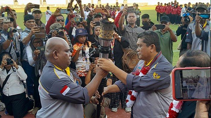 Ketua Panitia Porprov ke-1 Papua Selatan, Soleman jambormias (kiri) menyerahkan Obor Porprov Papua Selatan ke Penjabat Sekretaris Daerah Papua Selatan, Maddaremmeng (kanan) di Stadion Katapal Merauke. 
