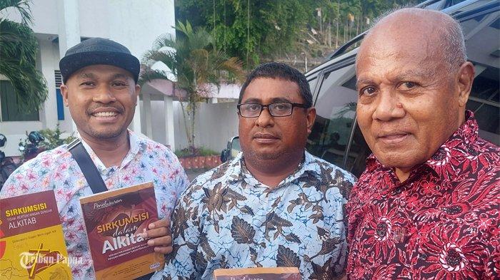 Tokoh kesehatan Papua, Constant Karma saat meberikan buku pentingnya Sirkumsisi hasil karyanya kepada dua anak muda di Kantor Gubernur Provinsi Papua, Rabu (25/10/2023).