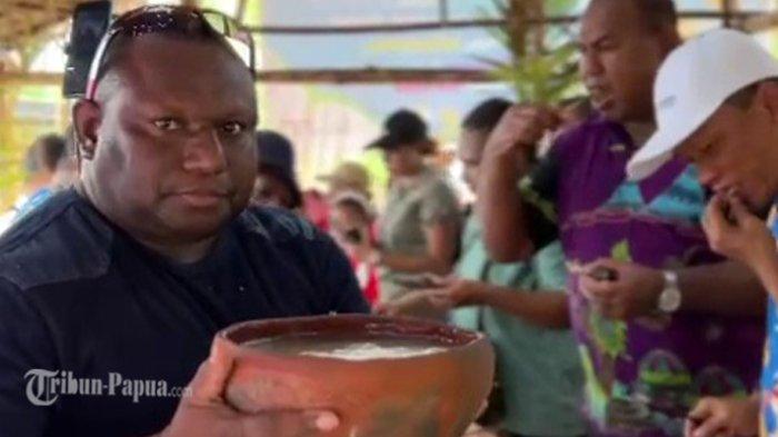 Kepala Diskominfo Kabupaten Jayapura, Gustaf Griapon saat memenang Sempe yang berisi papeda di Kampung Abar.
