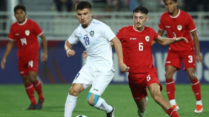 BEREBUT BOLA - Penyerang Uzbekistan, Khusayin Norchaev, dibayangi gelandang Indonesia, Ivar Jenner, saat pertandingan semifinal Piala Asia U-23 antara Indonesia dan Uzbekistan di Stadion Abdullah Bin Khalifa, Doha, Qatar, Senin (29/4/2024). AFP/KARIM JAAFAR