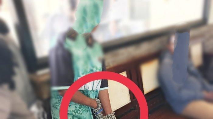 ISTRI DIGEMBOK- Nampak seorang ibu  brinisial R digembok tangannya menggunakan rantai besi oleh suaminya di Mimika, Papua Tengah, Kamis (6/3/2025).