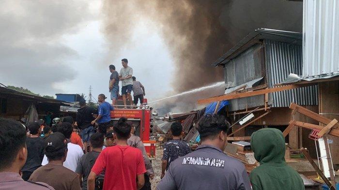 PEMADAMAN - Tampak warga bersama tim pemadam kebakaran berupaya memadamkan api yang menyulut tiga titik di kawasan Pasar Youtefa, Kota Jayapura, Minggu (07/01/2024) pagi. Kebakaran pada tiga lokasi bersamaan diduga sengaja dilakukan oknum tertentu.
