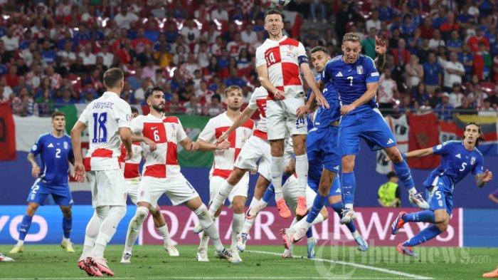 Penyerang Kroasia #14 Ivan Perisic (tengah) memenangkan sundulan selama pertandingan sepak bola Grup B UEFA Euro 2024 antara Kroasia dan Italia di Stadion Leipzig di Leipzig pada 24 Juni 2024.
