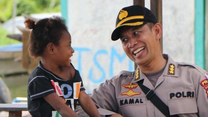 Kabid Humas Polda Papua Kombes AM Kamal saat bercanda dengan salah satu anak dari korban banjir bandang di Kabupaten Jayapura beberapa tahun lalu