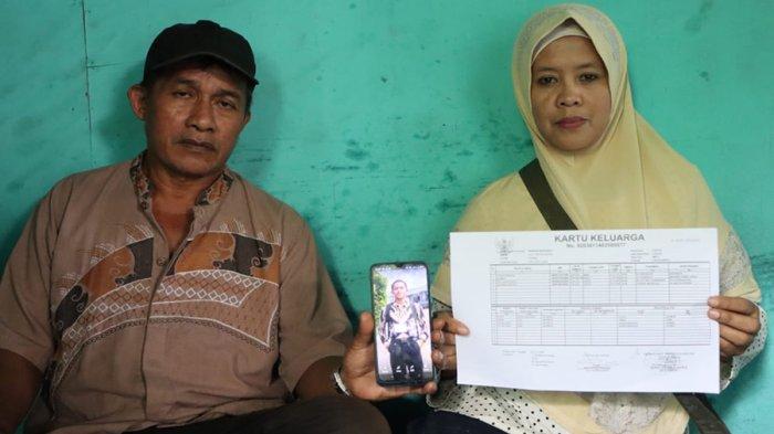 Pasangan Wawan Indrawan dan Normah, penjual nasi kuning di Kabupaten Fakfak, Papua Barat, menunjukkan foto putra mereka, Dwi Wahid Saputra Wahid (18), yang lolos seleksi bintara polisi, Rabu (17/7/2023).