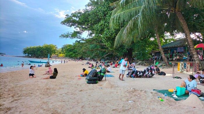 PASIR PUTIH – Suasana di objek wisata Pantai Pasir Putih di Manokwari, Papua Barat, yang ramai dikunjungi saat H+2 Lebaran, Senin (24/4/2023) sore. Geliat pariwisata membawa rezeki bagi para pelaku usaha di Pantai Pasir Putih.