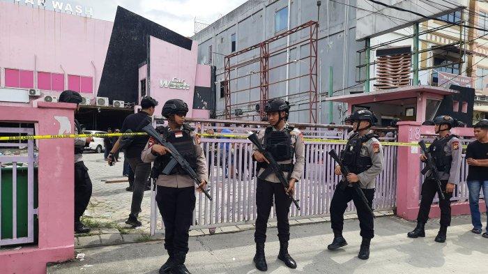 Para personel Brimob Polda Riau berjaga di depan car wash Jalan Tuanku Tambusai Pekanbaru pasca ricuh Senin siang.